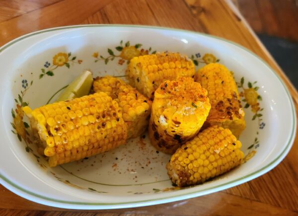 Grilled Elote with Miso Butter, Togarashi, Chives, Sesame Seeds, Lime. 