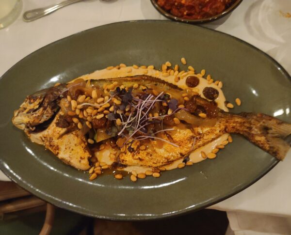 Whole roasted pompano with tahini, raisins and pine nuts