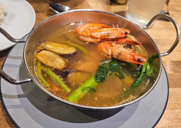 Seafood Sinigang, a Filipino style hot pot soup with tamarind broth, Clams, whole Kauai shrimp and local fish.