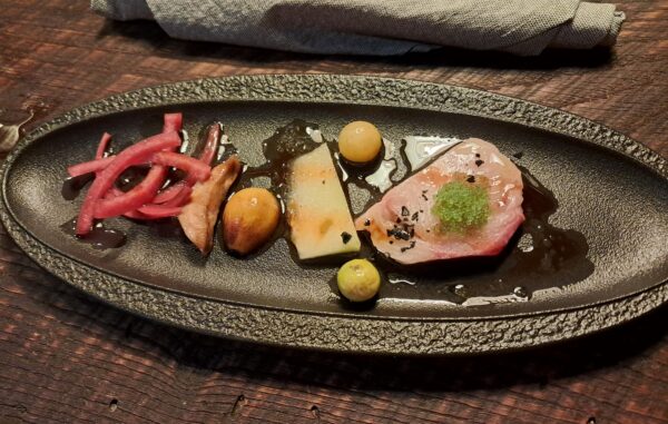 Hamachi sashimi with pickled raptor melon, celery root misozuki, wasabi tobiko, ground cherries, crispy nori, smoked watermelon hot sauce and passion fruit vinegar walking garlic oil